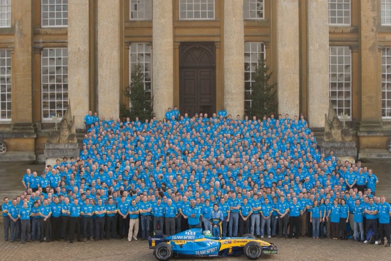 Several hundred Renault F1 Team staff in blue team shirts on the steps of Blenheim Palace, with the team’s car in front.